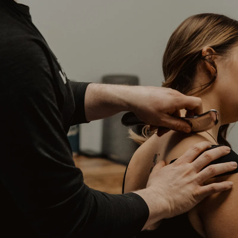Instrument-assisted soft tissue mobilization on upper back to relieve muscle tension