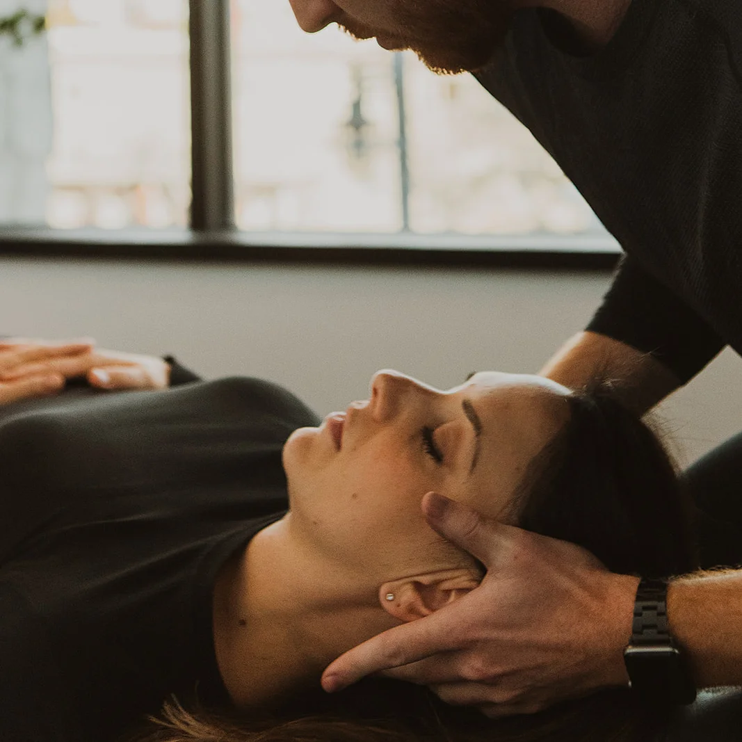 Physiotherapist applying cervical manual therapy to patient for TMJ jaw pain and neck tension relief in Kelowna