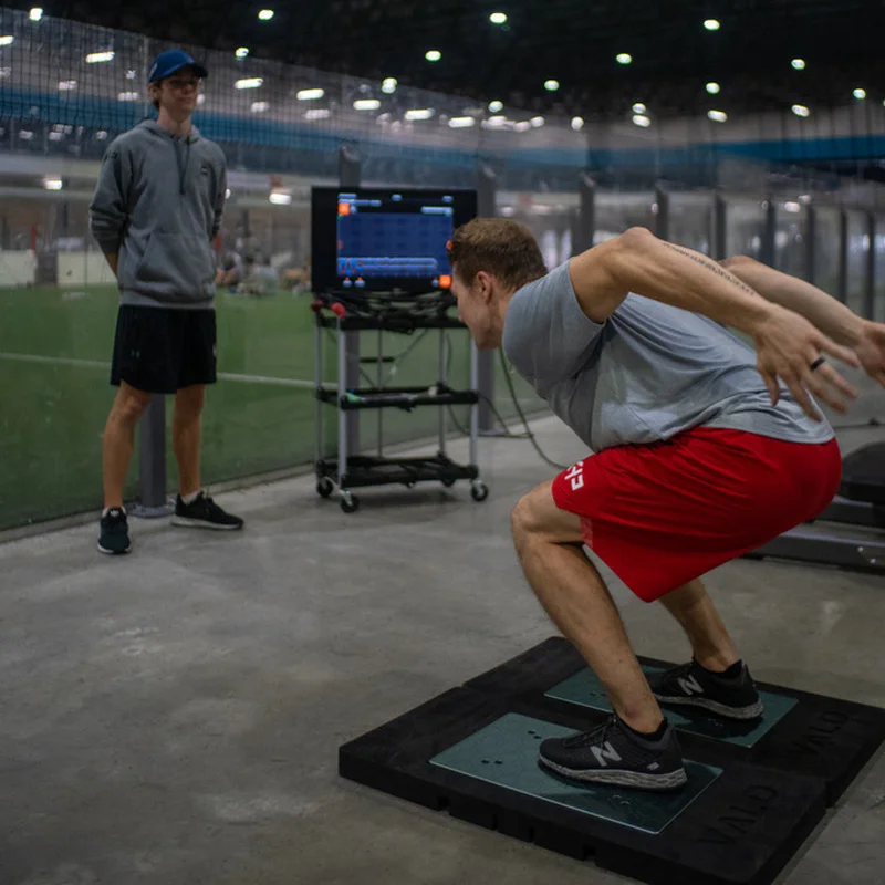 Kinesiologist observing athlete during VALD force plate testing session in Kelowna