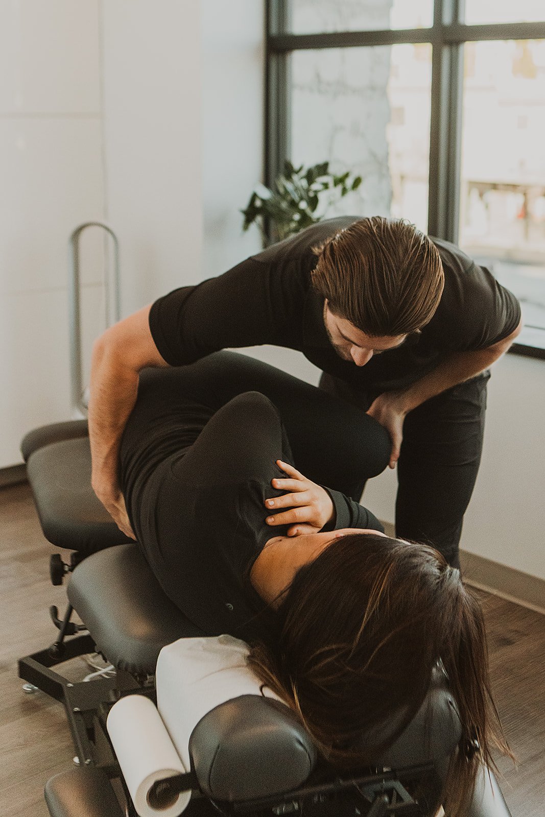 Chiropractor adjusting a patient’s lower back on a Pro Motion Clinic treatment table