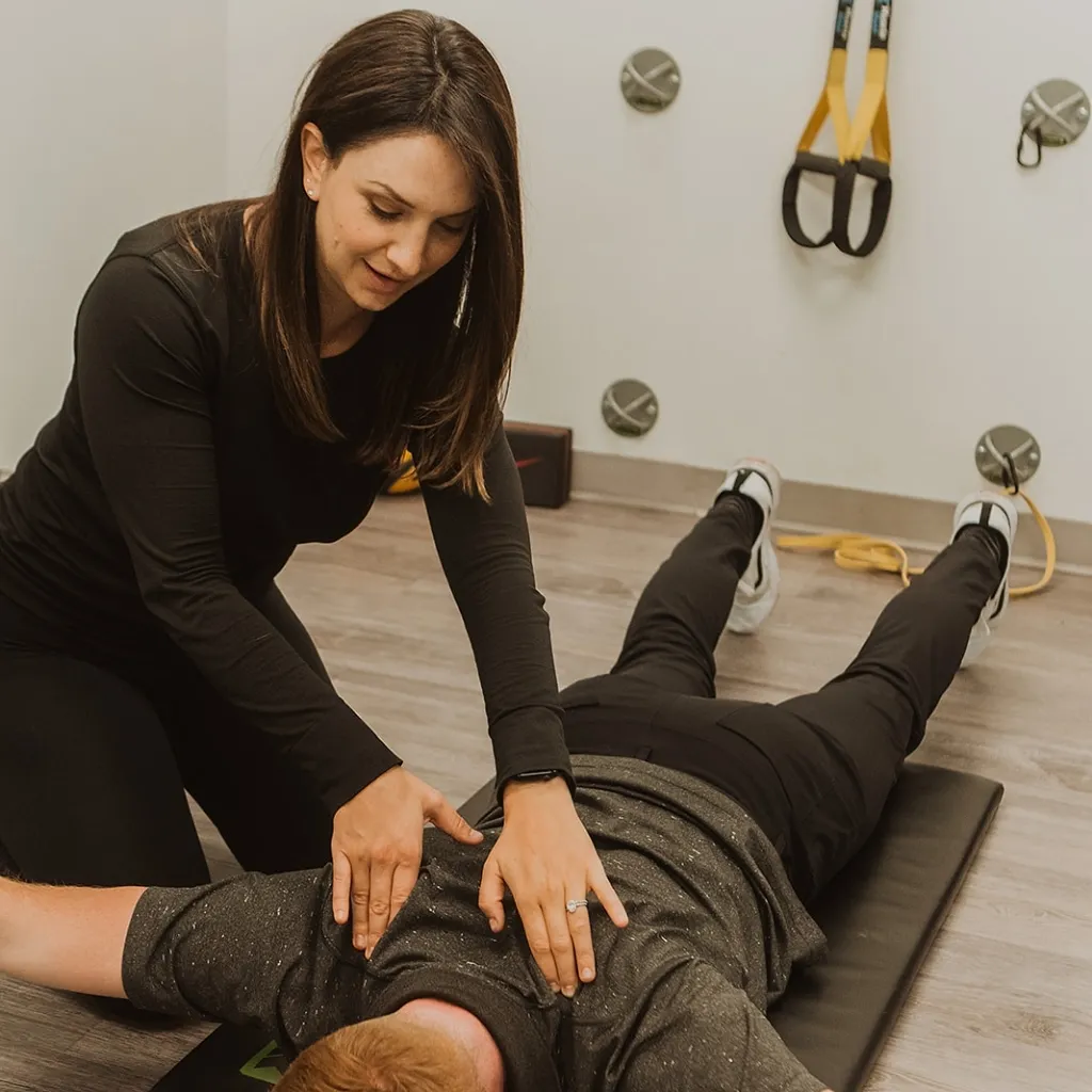 Registered massage therapist performing abdominal muscle testing during NeuroKinetic therapy session in Kelowna clinic