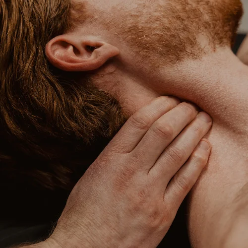 Neck muscle tension and pain area being assessed during massage therapy treatment