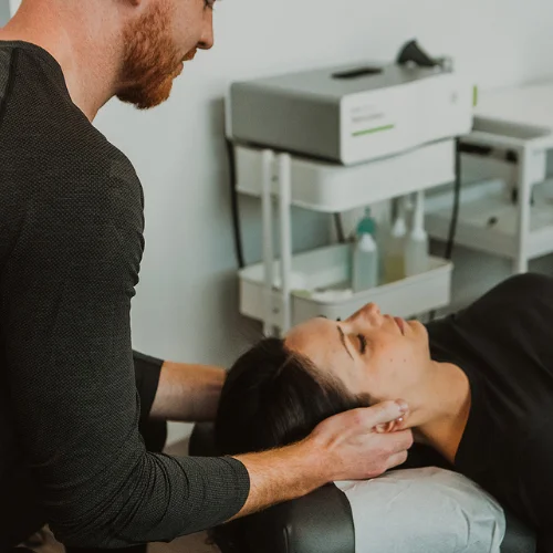 Physiotherapist performing gentle neck therapy to relieve tension and improve mobility