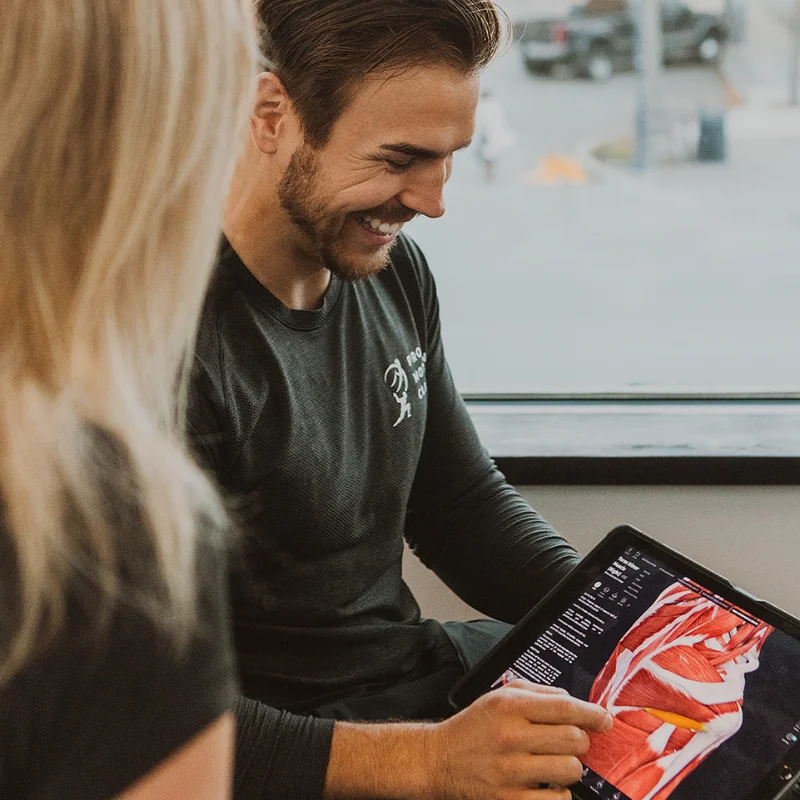 Chiropractor explaining muscle structure and treatment plan including therapeutic ultrasound in Kelowna