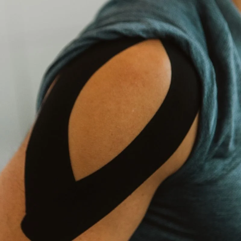 Completed kinesiology tape Y-strip applied to patient's shoulder for rotator cuff support in Kelowna