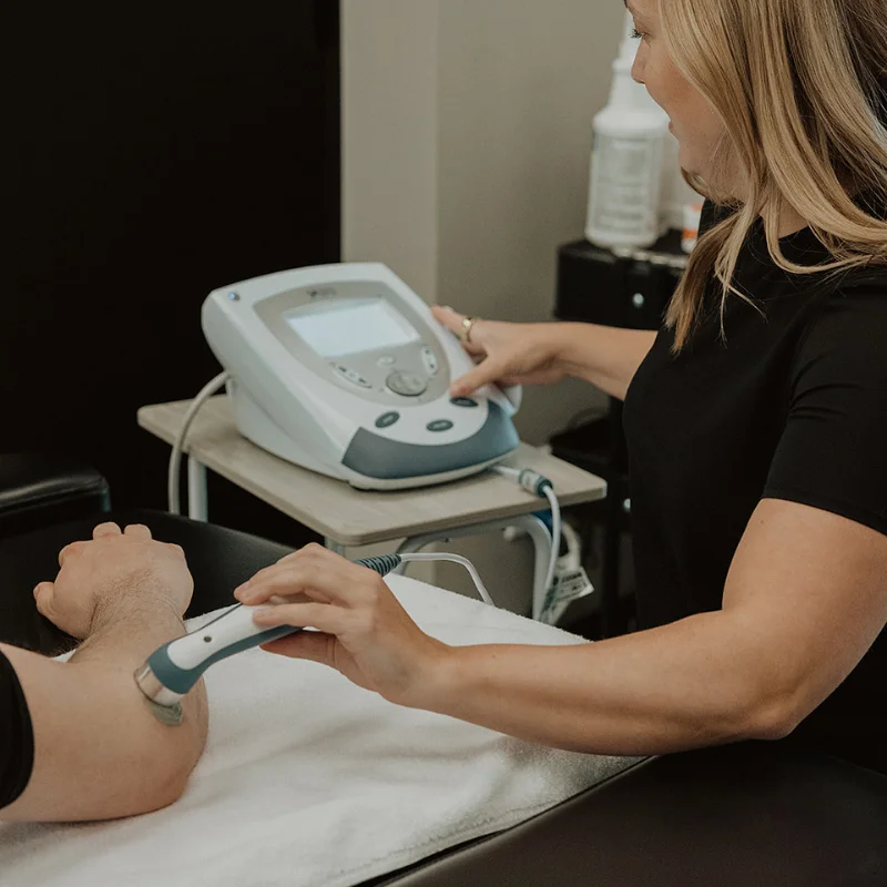 Chiropractor performing therapeutic ultrasound therapy for soft tissue recovery at Pro Motion Clinic