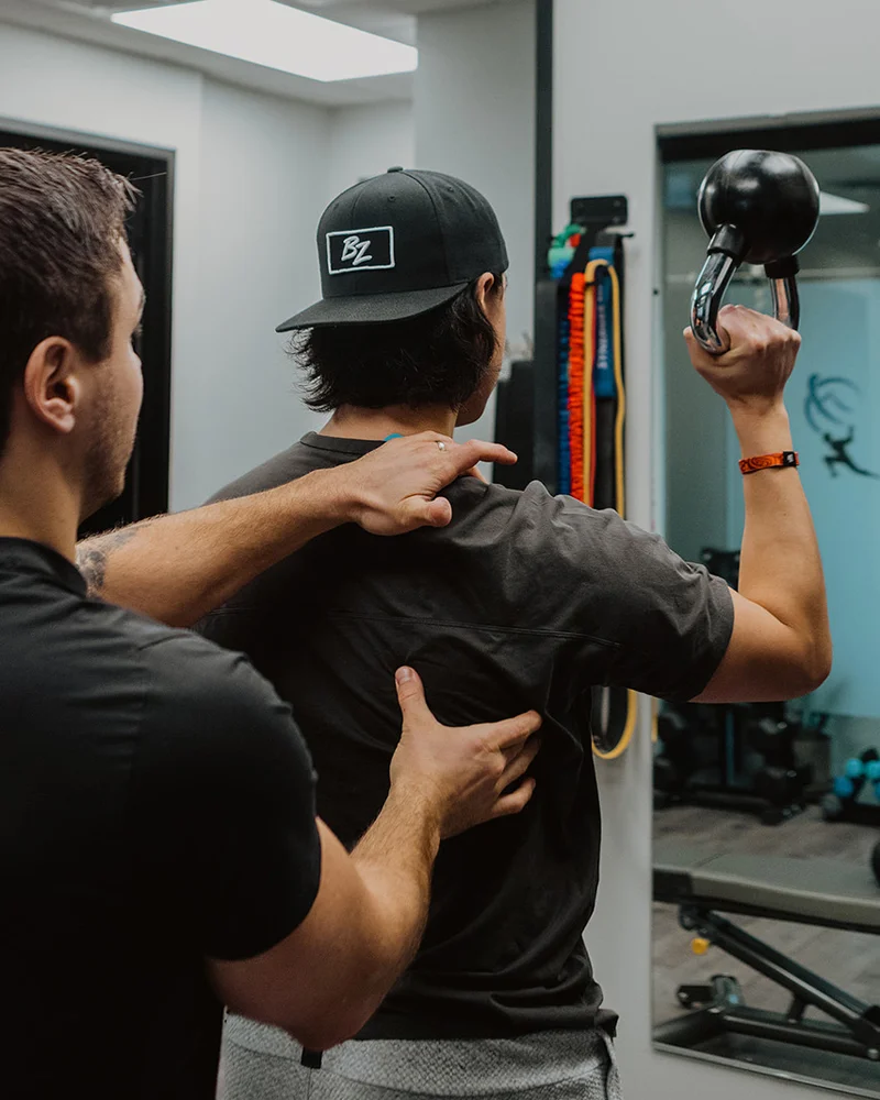 Guided shoulder stability exercise with kinesiologist at Pro Motion Clinic Kelowna