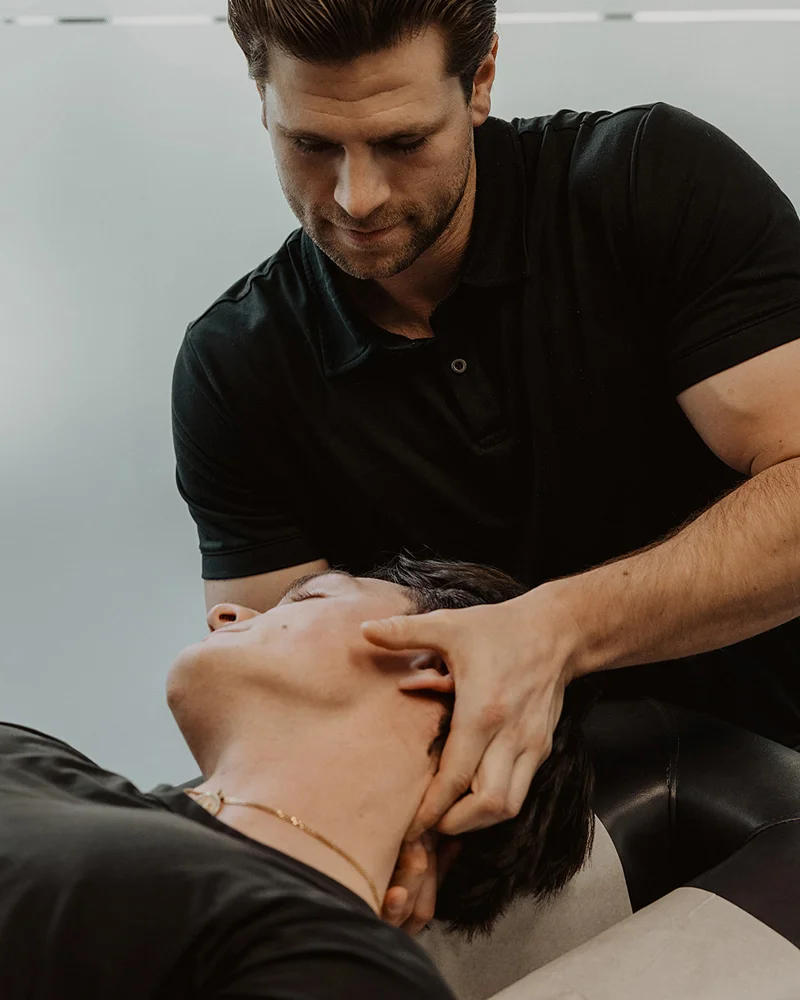 Registered massage therapist performing cervical traction for post-concussion neck pain and headache relief in Kelowna