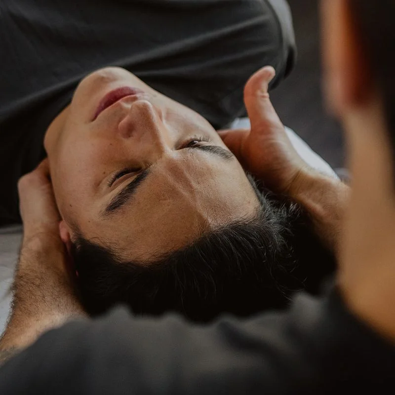 Therapist providing head and neck support during concussion management session in Kelowna
