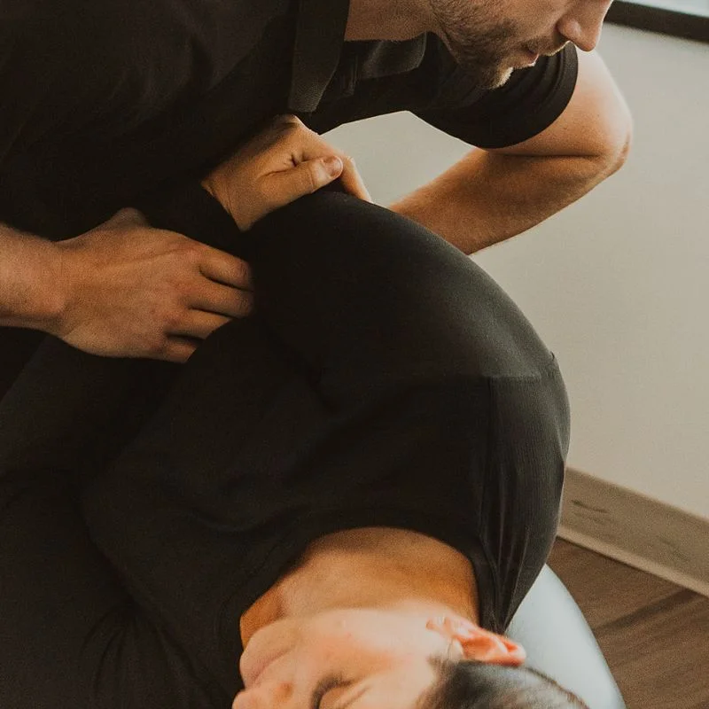 Chiropractor performing spinal adjustment to relieve back pain at clinic in Kelowna