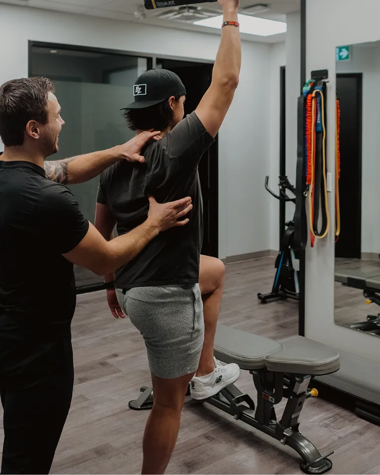 Chiropractor guiding patient through corrective exercise to improve posture and mobility in Kelowna