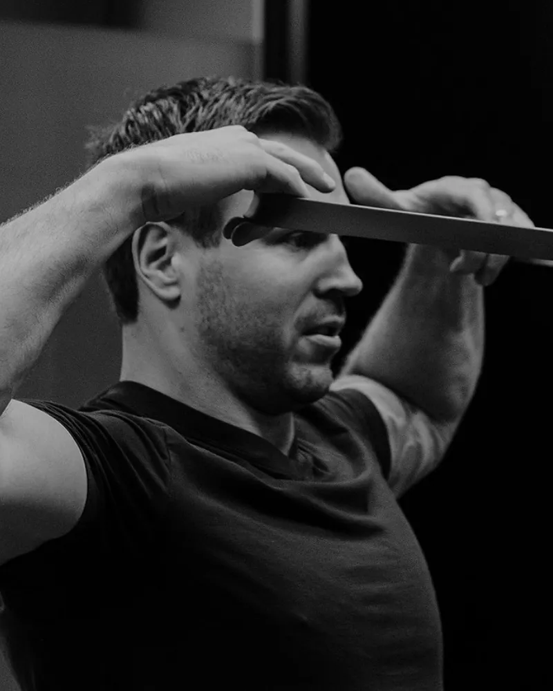 Resistance band shoulder activation exercise guided by kinesiologist at Pro Motion Clinic