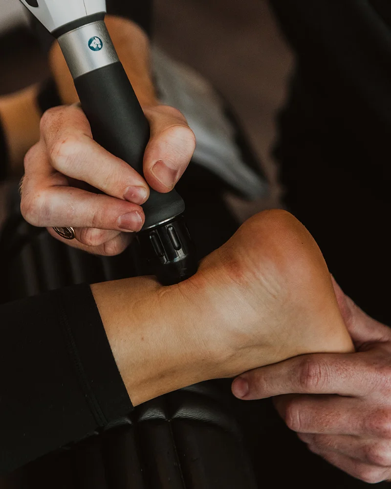 Shockwave therapy applied to heel for pain relief and tissue recovery in physiotherapy