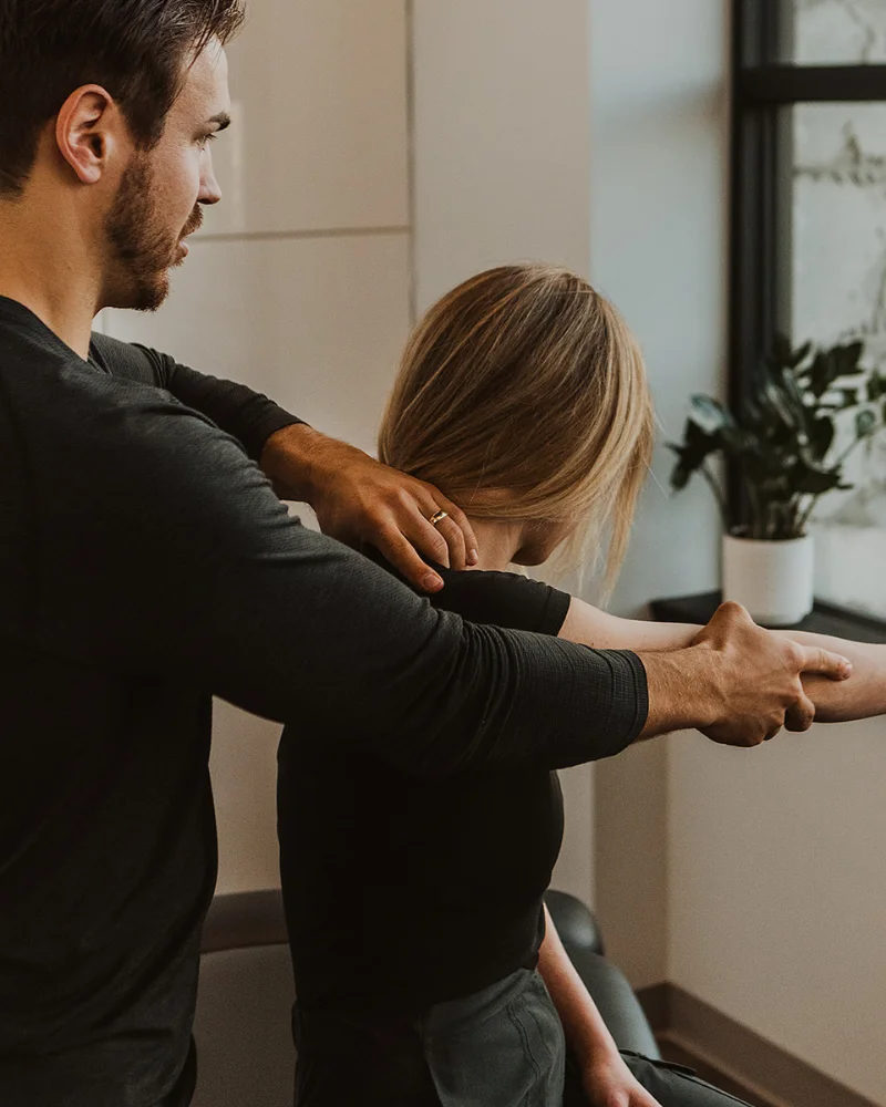 Therapist guiding shoulder movement during myofascial release therapy session in Kelowna