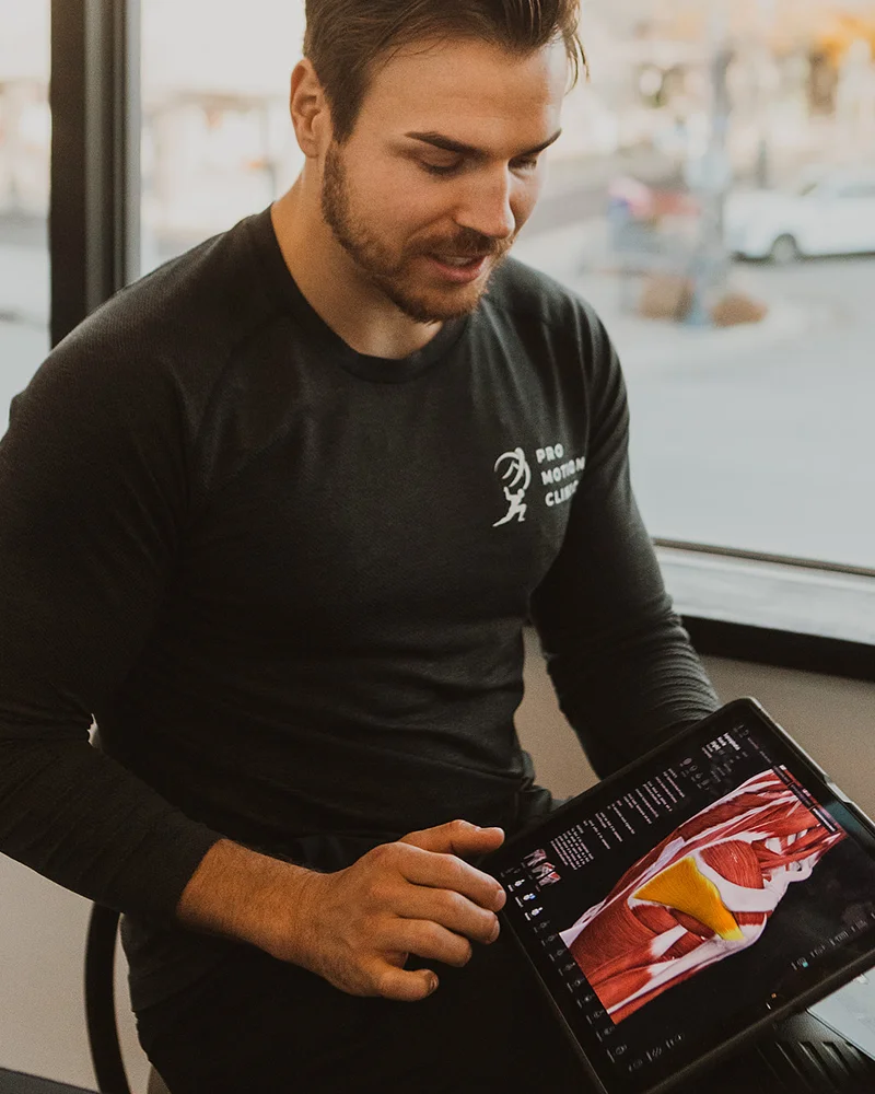 Clinician reviewing muscle and movement data during concussion testing at Pro Motion Clinic Kelowna