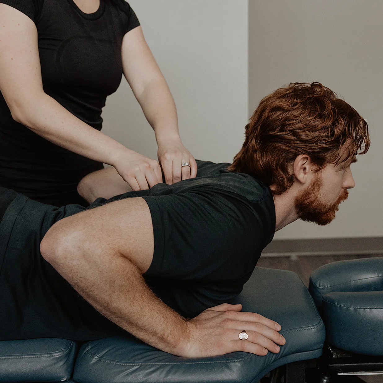 Massage therapist applying spinal manual therapy during clinical Pilates movement session in Kelowna