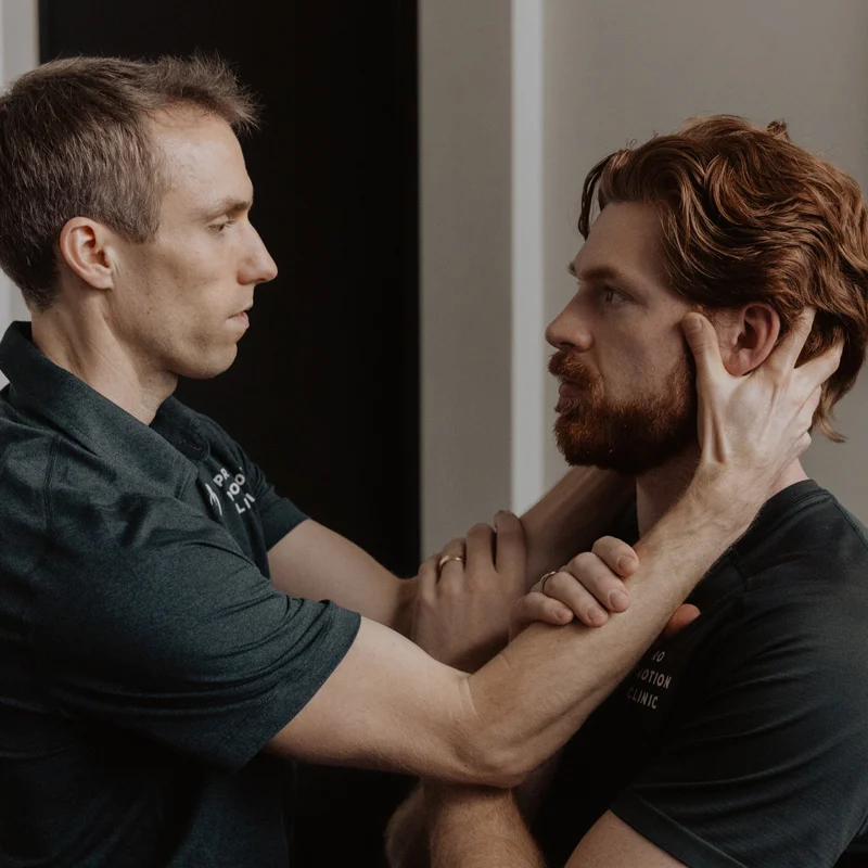 Chiropractor assessing patient's jaw and cervical spine alignment for vestibular and balance disorder treatment in Kelowna