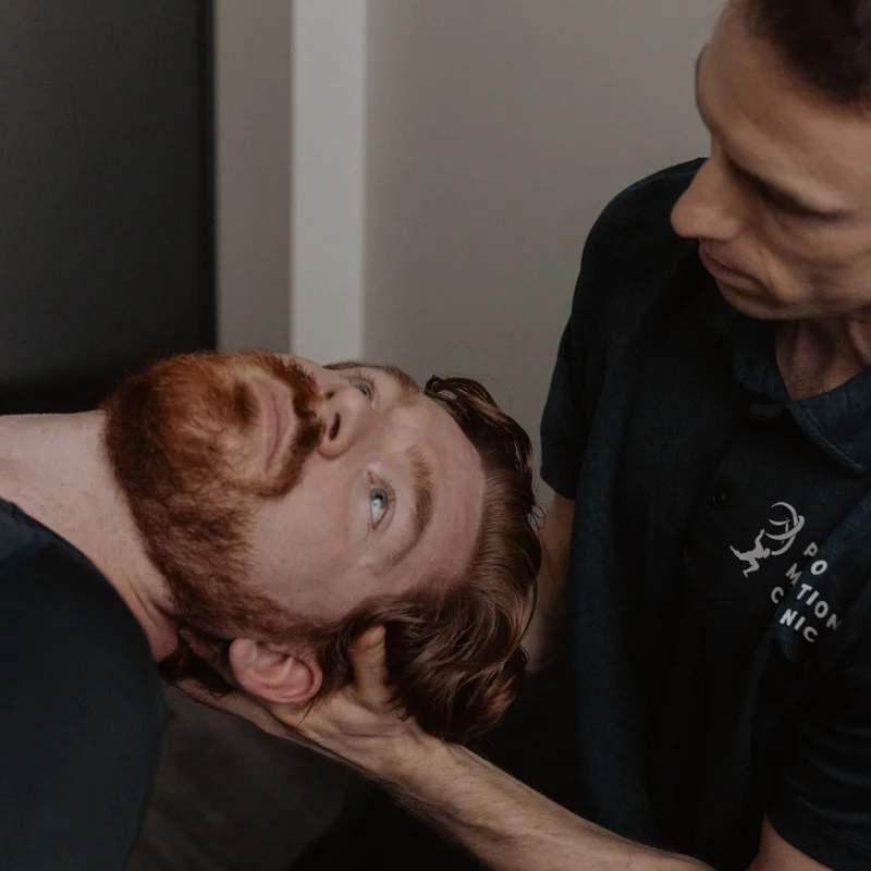 Chiropractor performing cervical repositioning manoeuvre on patient for vestibular therapy and vertigo treatment in Kelowna