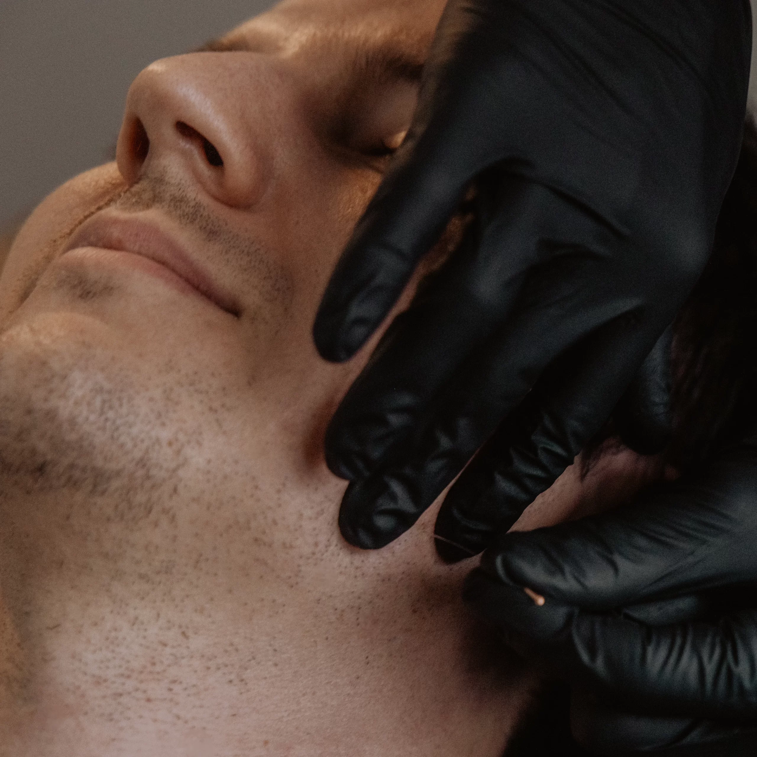 Physiotherapist performing hands-on TMJ joint mobilization on patient's jaw for jaw pain treatment in Kelowna