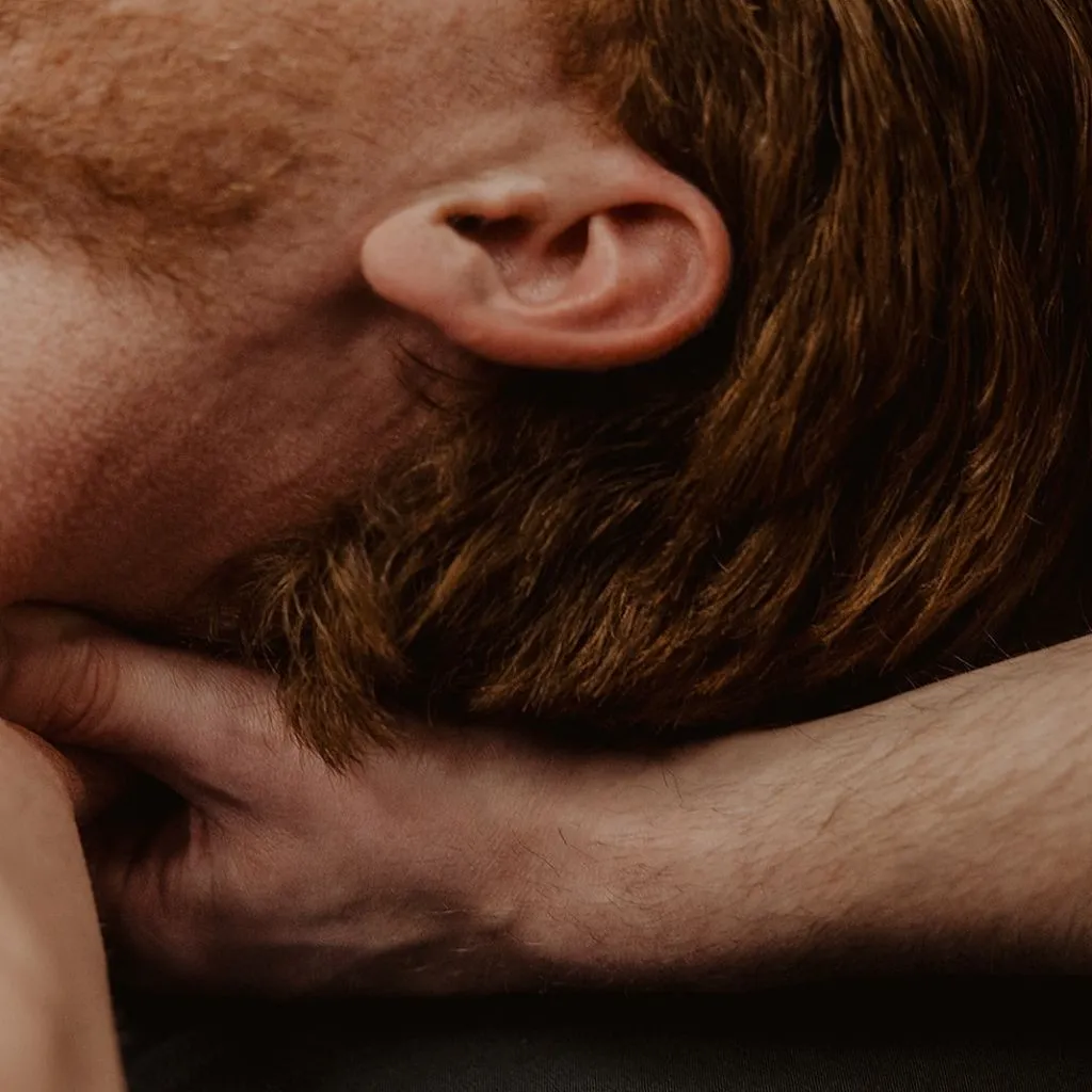 Close-up of massage therapist performing suboccipital release for tension headache relief in Kelowna