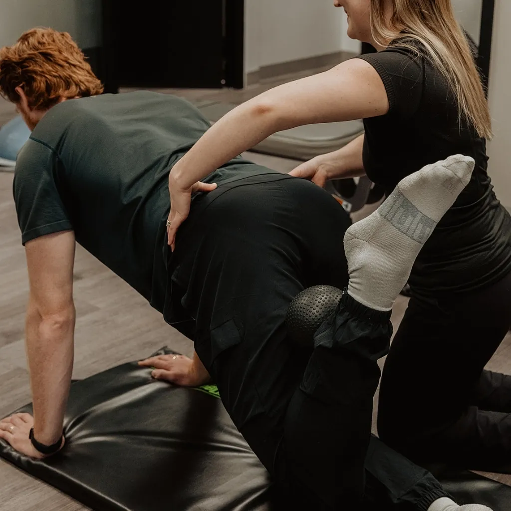Registered massage therapist assessing spinal stability and movement patterns during NeuroKinetic therapy in Kelowna