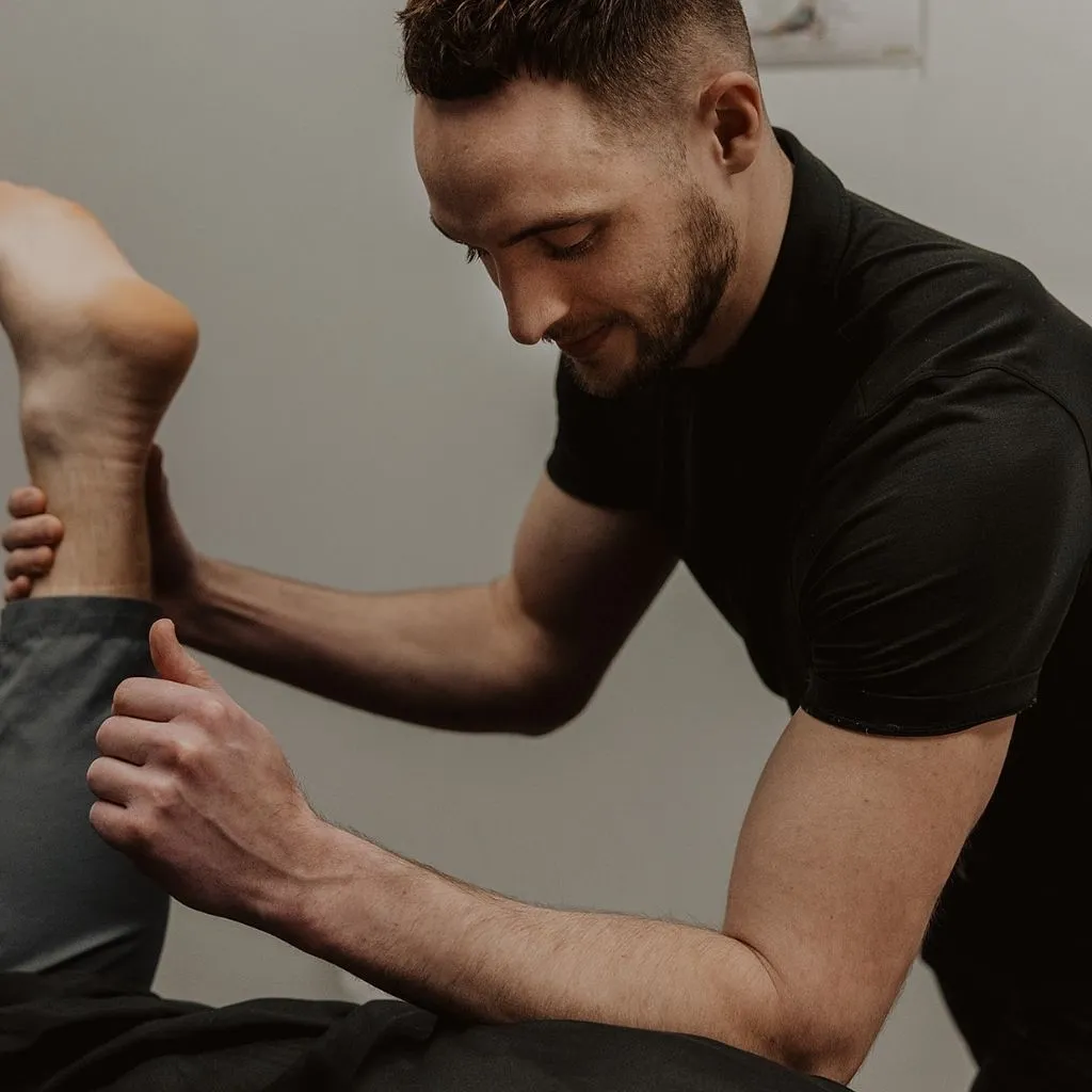 Registered massage therapist applying deep tissue forearm pressure to patient's upper back in Kelowna