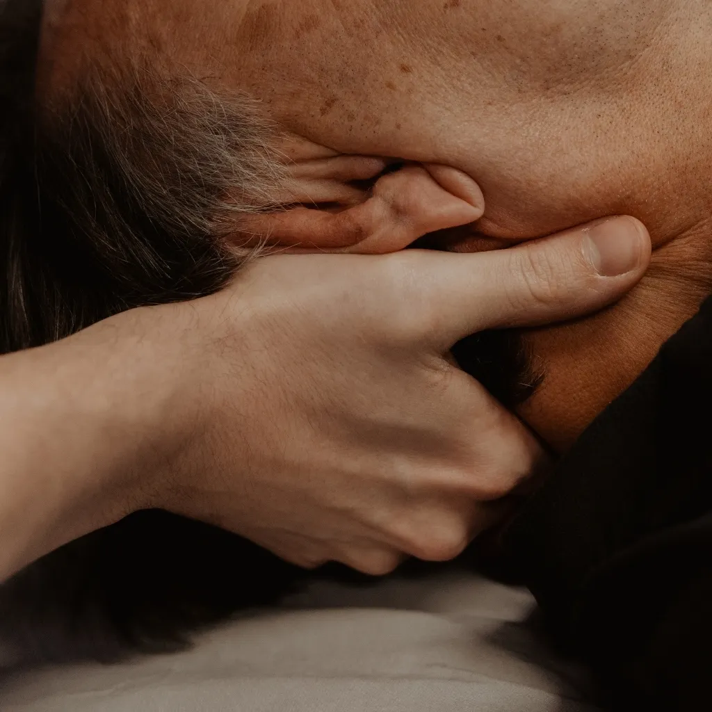 Physiotherapist applying gentle cervical joint mobilization to older patient for osteoarthritis pain management in Kelowna