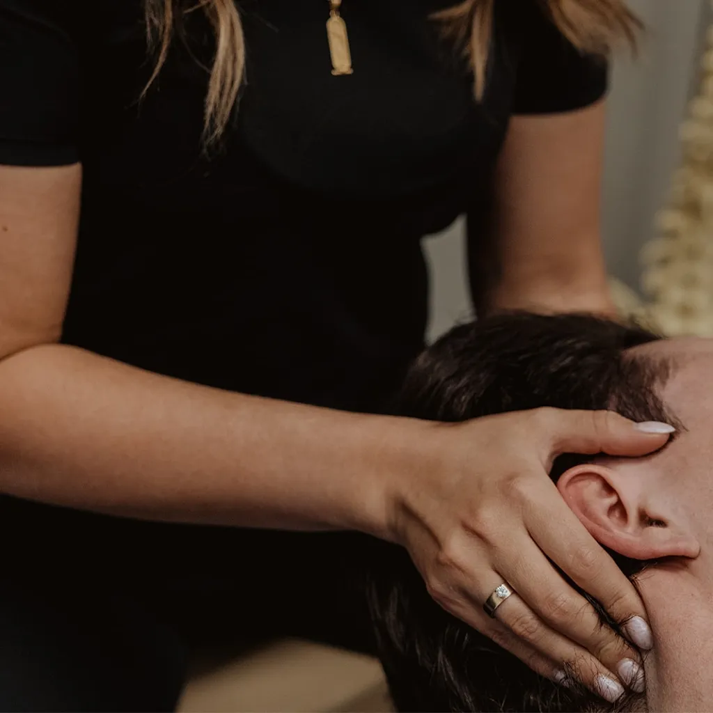 Registered massage therapist applying cranial and temporal massage for migraine and headache relief in Kelowna