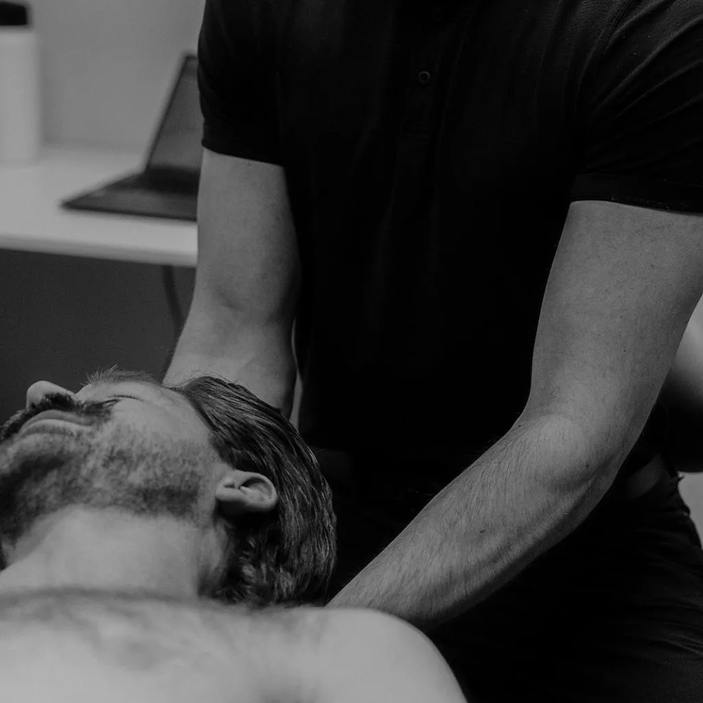 Registered massage therapist performing cervical traction on patient for headache and migraine relief in Kelowna