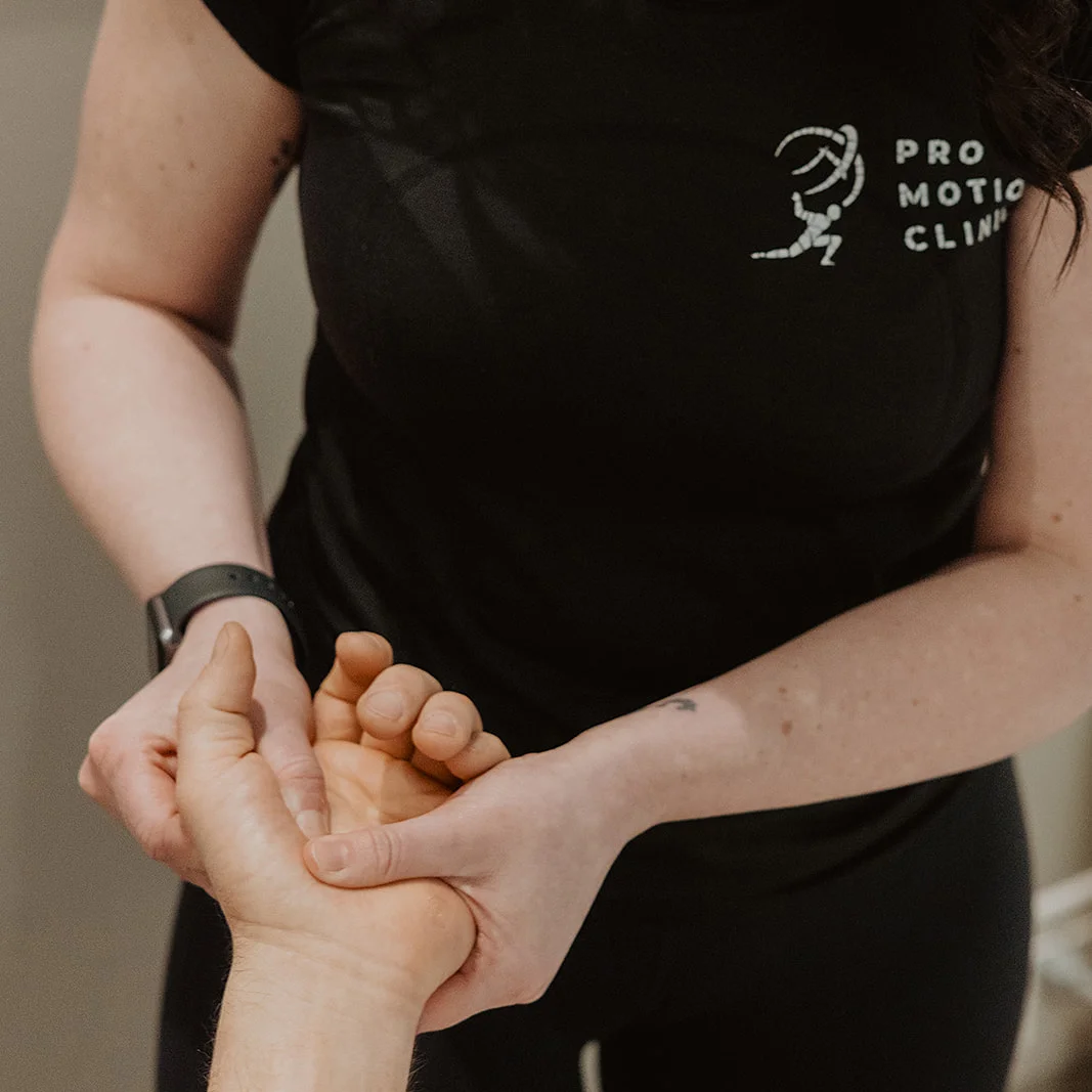 Pro Motion Clinic registered massage therapist performing hand and finger massage during paediatric treatment in Kelowna