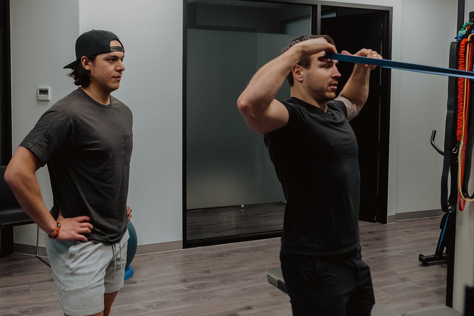 Athlete performing resistance band shoulder exercise under supervision at Pro Motion Clinic Kelowna